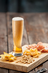 Image showing Beer glass and potato chips, pistachios isolated on a white