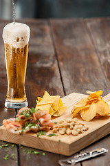 Image showing Beer glass and potato chips, pistachios isolated on a white