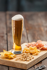 Image showing Beer glass and potato chips, pistachios isolated on a white