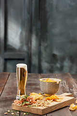 Image showing Beer glass and potato chips, pistachios isolated on a white