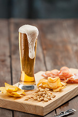 Image showing Beer glass and potato chips, pistachios isolated on a white