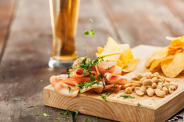 Image showing Beer glass and potato chips, pistachios isolated on a white