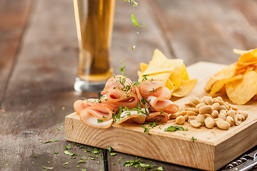 Image showing Beer glass and potato chips, pistachios isolated on a white