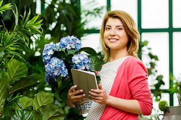 Image showing Woman with bouquet and tablet
