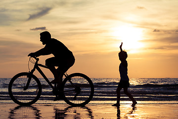 Image showing Father and son playing on the beach at the day time.