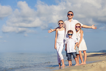 Image showing Father and children playing on the beach at the day time.