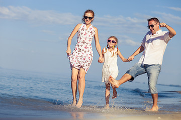 Image showing Happy family walking on the beach at the day time.