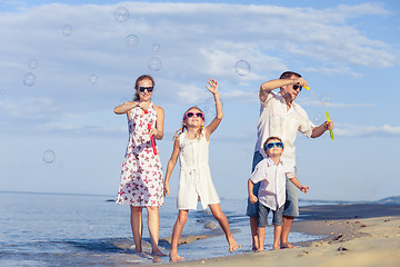 Image showing Happy family walking on the beach at the day time.