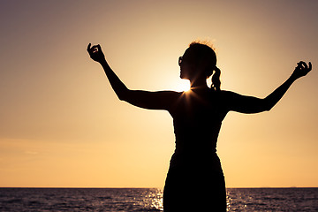 Image showing woman open arms under the sunset at sea.