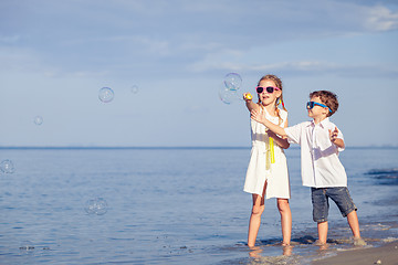 Image showing Sister and brother playing on the beach at the day time. 