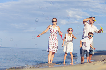 Image showing Happy family walking on the beach at the day time.