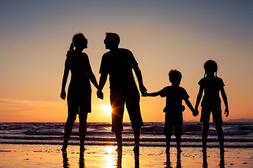 Image showing Silhouette of happy family who playing on the beach at the sunse