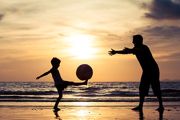 Image showing Father and son with ball playing soccer on the beach at the day 