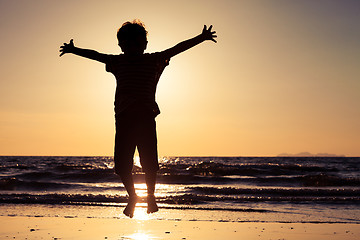 Image showing Happy little boy jumping on the beach 