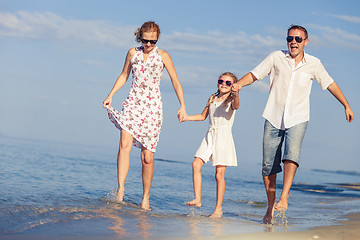 Image showing Happy family walking on the beach at the day time.