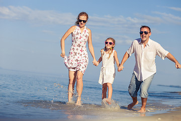 Image showing Happy family walking on the beach at the day time.