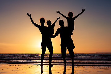 Image showing Silhouette of happy family who playing on the beach at the sunse