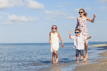 Image showing Mother and children playing on the beach at the day time.