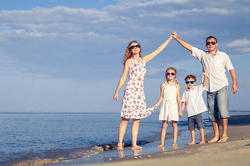 Image showing Happy family walking on the beach at the day time.