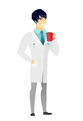 Image showing Young asian doctor holding cup of coffee.