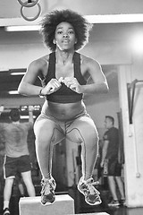 Image showing black female athlete is performing box jumps at gym