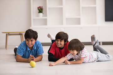 Image showing boys having fun with an apple on the floor