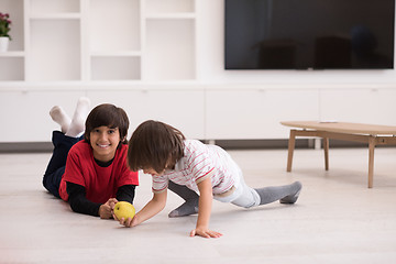 Image showing boys having fun with an apple on the floor