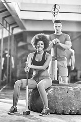 Image showing multiethnic couple after workout with hammer