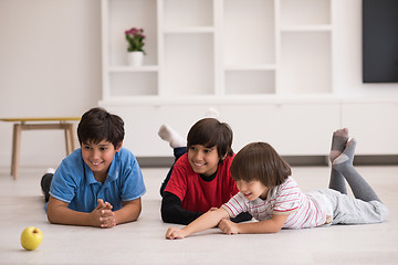 Image showing boys having fun with an apple on the floor