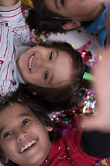 Image showing kids  blowing confetti while lying on the floor