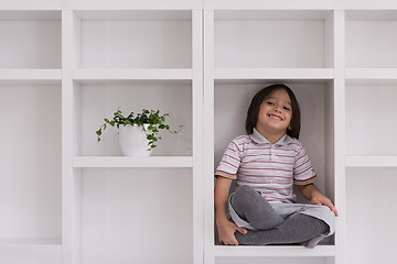 Image showing young boy posing on a shelf