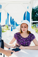 Image showing Smiling woman paying with smartphone