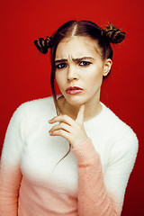 Image showing young pretty emitonal posing teenage girl on bright red background, happy smiling lifestyle people concept closeup