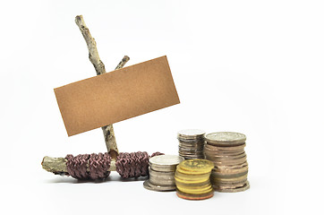 Image showing Paper sign board with stack of coins 