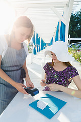 Image showing Woman paying for meal in cafe