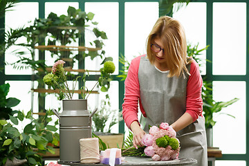 Image showing Woman in glasses makes bouquet