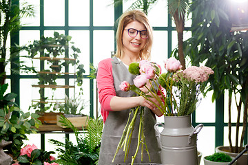 Image showing Young woman florist with glasses