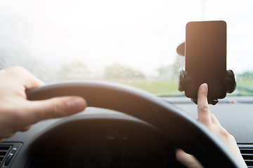 Image showing Man behind wheel with smartphone