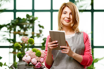 Image showing Florist with tablet in hands