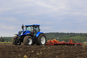 Image showing New Holland Tractor and Potila Harrow on Field