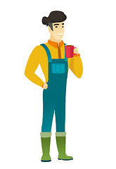 Image showing Young asian farmer holding cup of coffee.