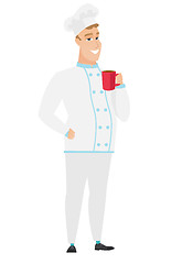 Image showing Young caucasian chef cook holding cup of coffee.