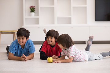 Image showing boys having fun with an apple on the floor