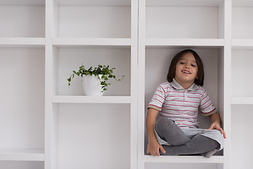 Image showing young boy posing on a shelf