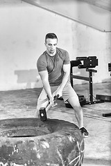 Image showing man workout with hammer and tractor tire