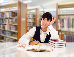 Image showing Young Female Mixed Race Student With Books and Paper Daydreaming