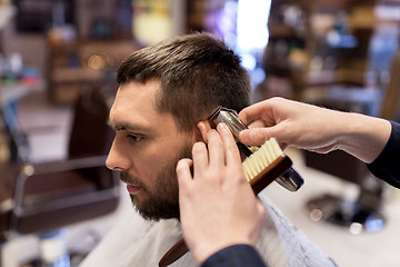 Image showing man and barber hands with trimmer cutting hair