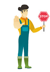 Image showing Asian farmer holding stop road sign.