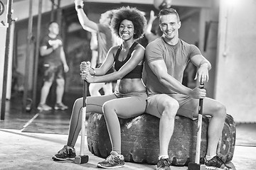 Image showing multiethnic couple after workout with hammer