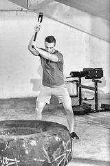 Image showing man workout with hammer and tractor tire